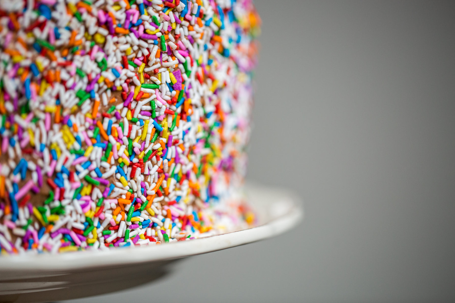 the cake is covered with sprinkles and multi - colored frosting