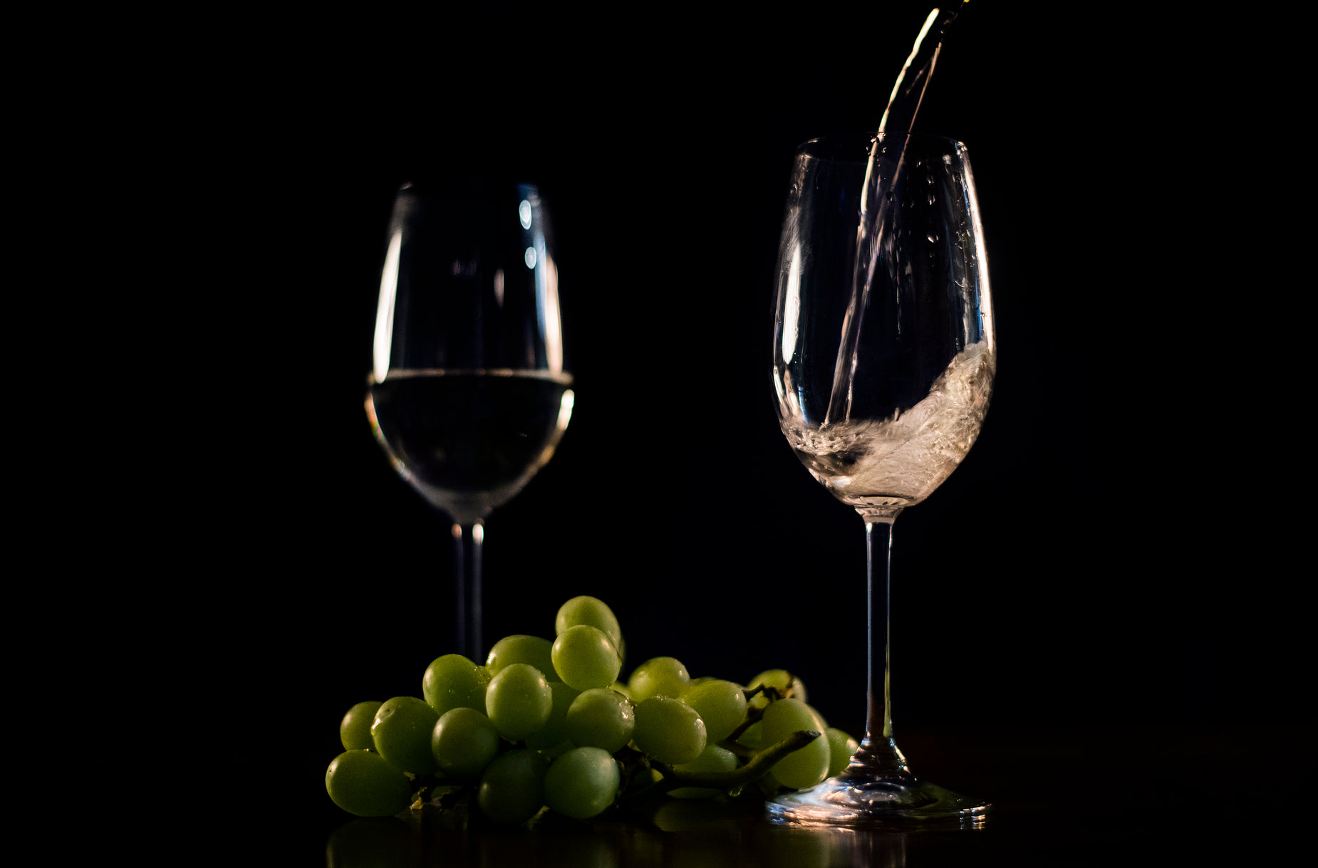 a glass and some gs with a wine bottle