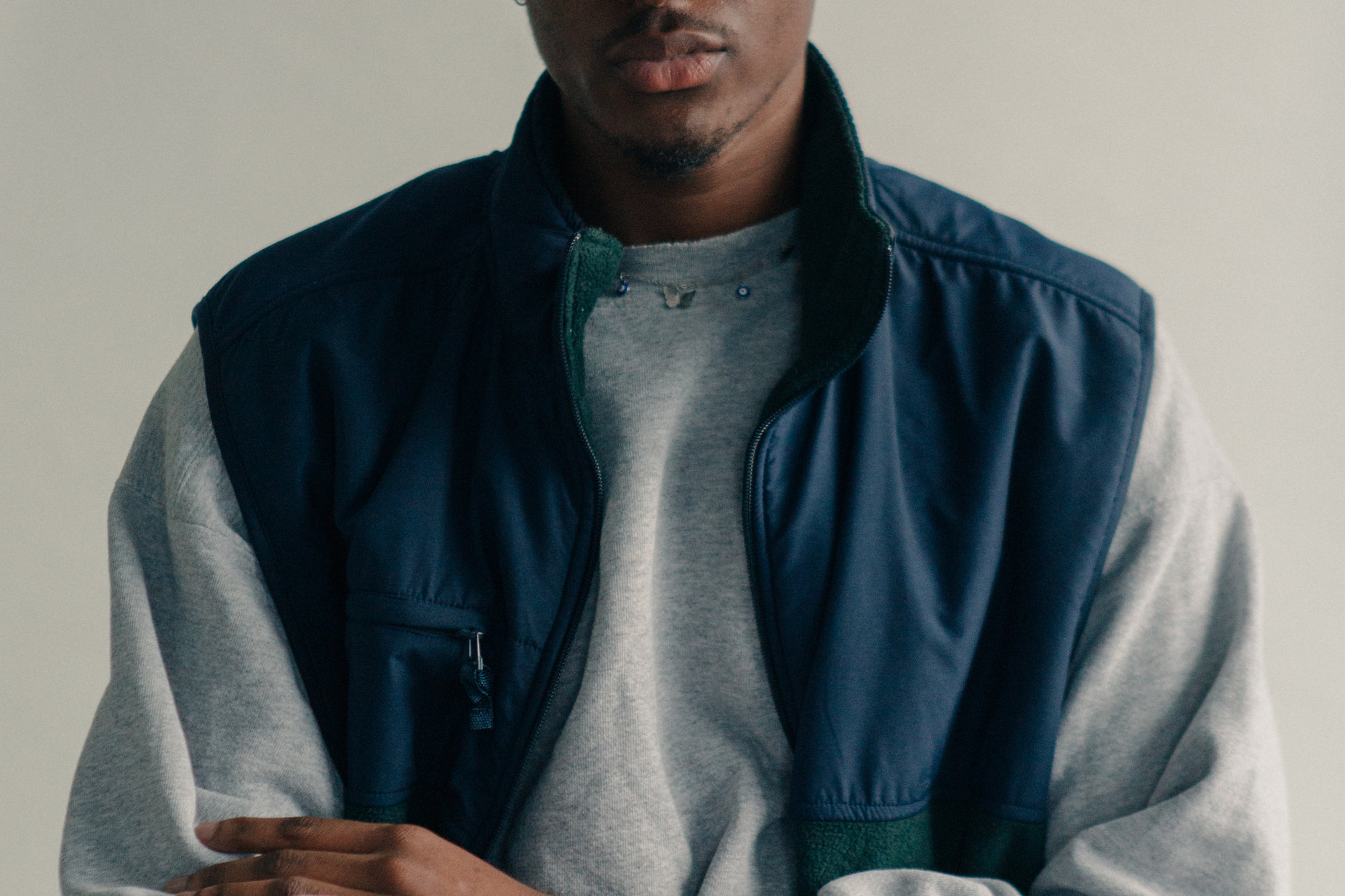 a young man wearing a jacket while holding a remote