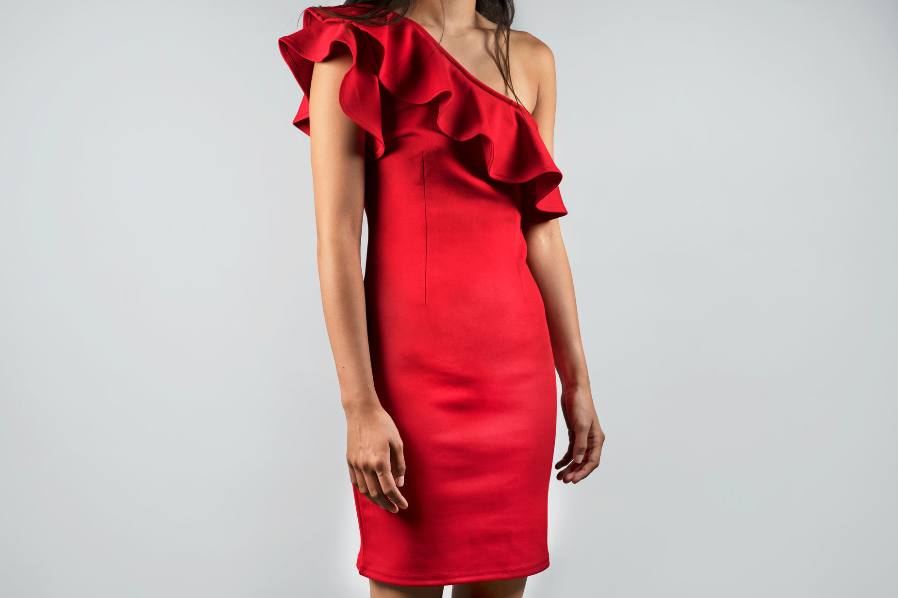 a model in a red dress with a ruffle over the shoulder