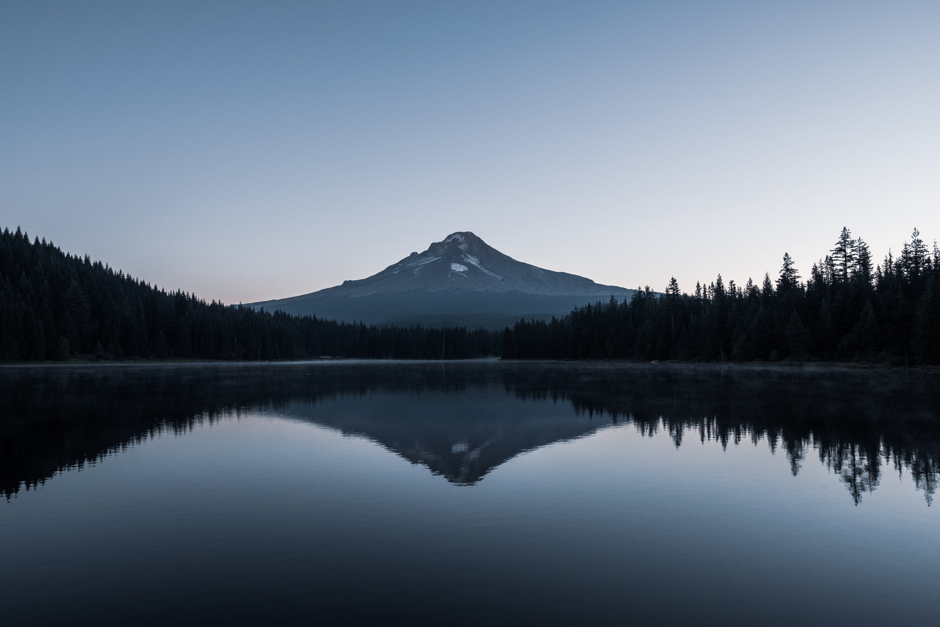 a large body of water in front of a mountain