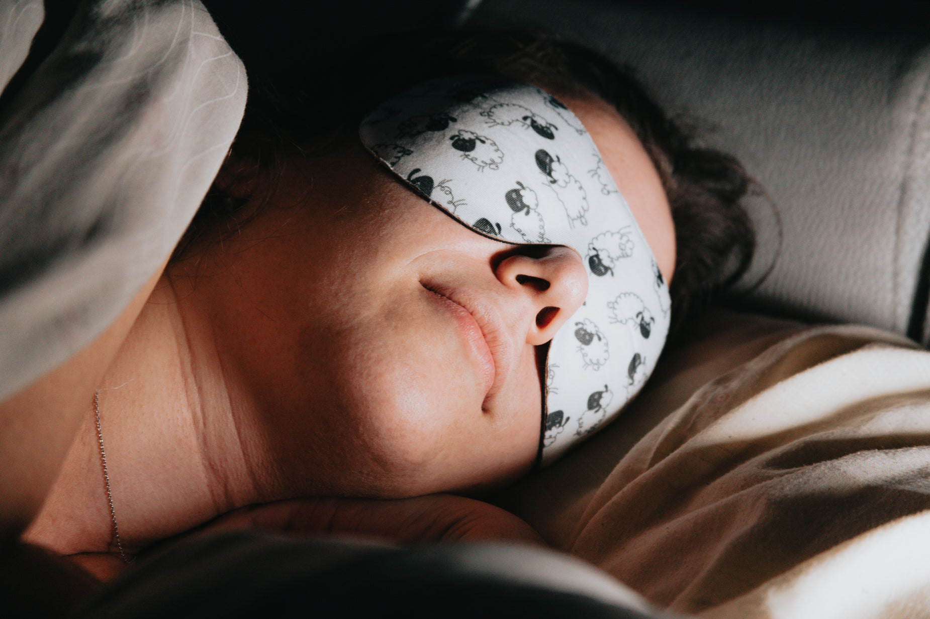 a woman sleeping with a blindfold on her face