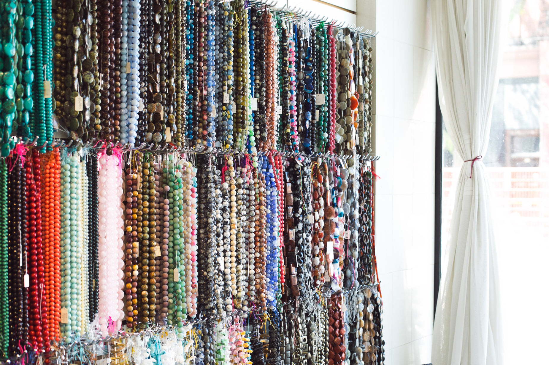 beads hanging on a wall in front of a window