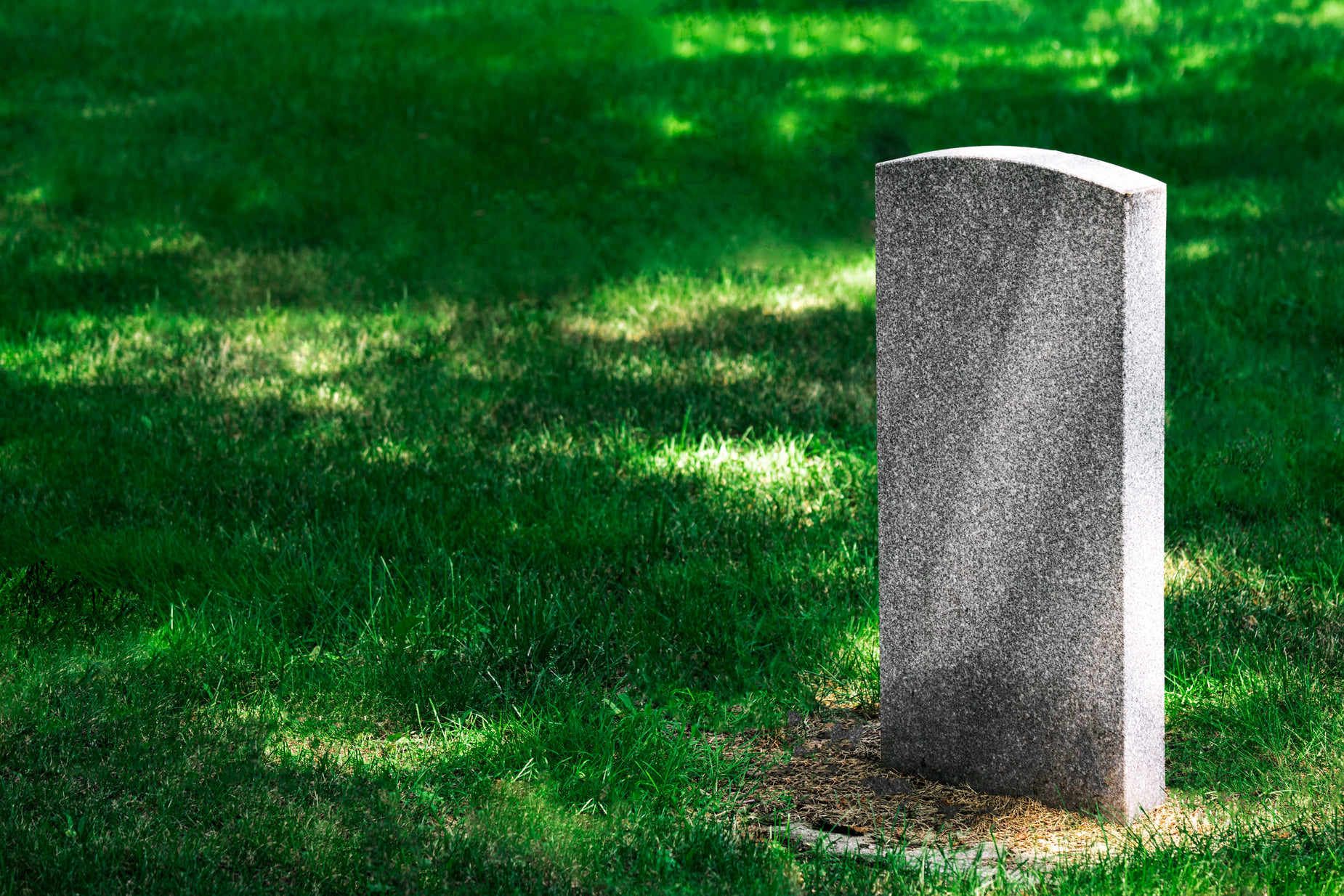 a tall cement monument laying in the grass