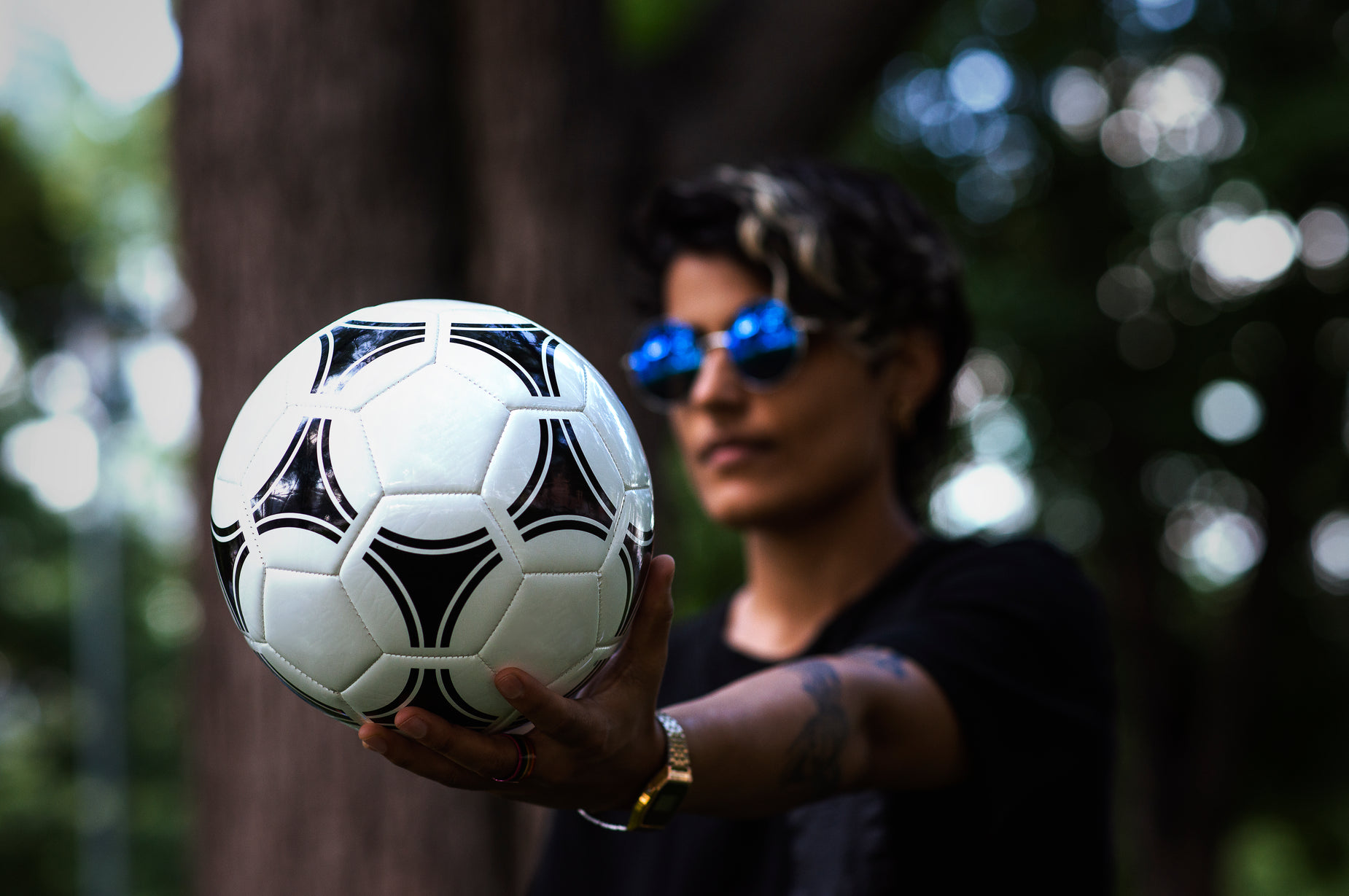 a man holding a soccer ball on top of his finger