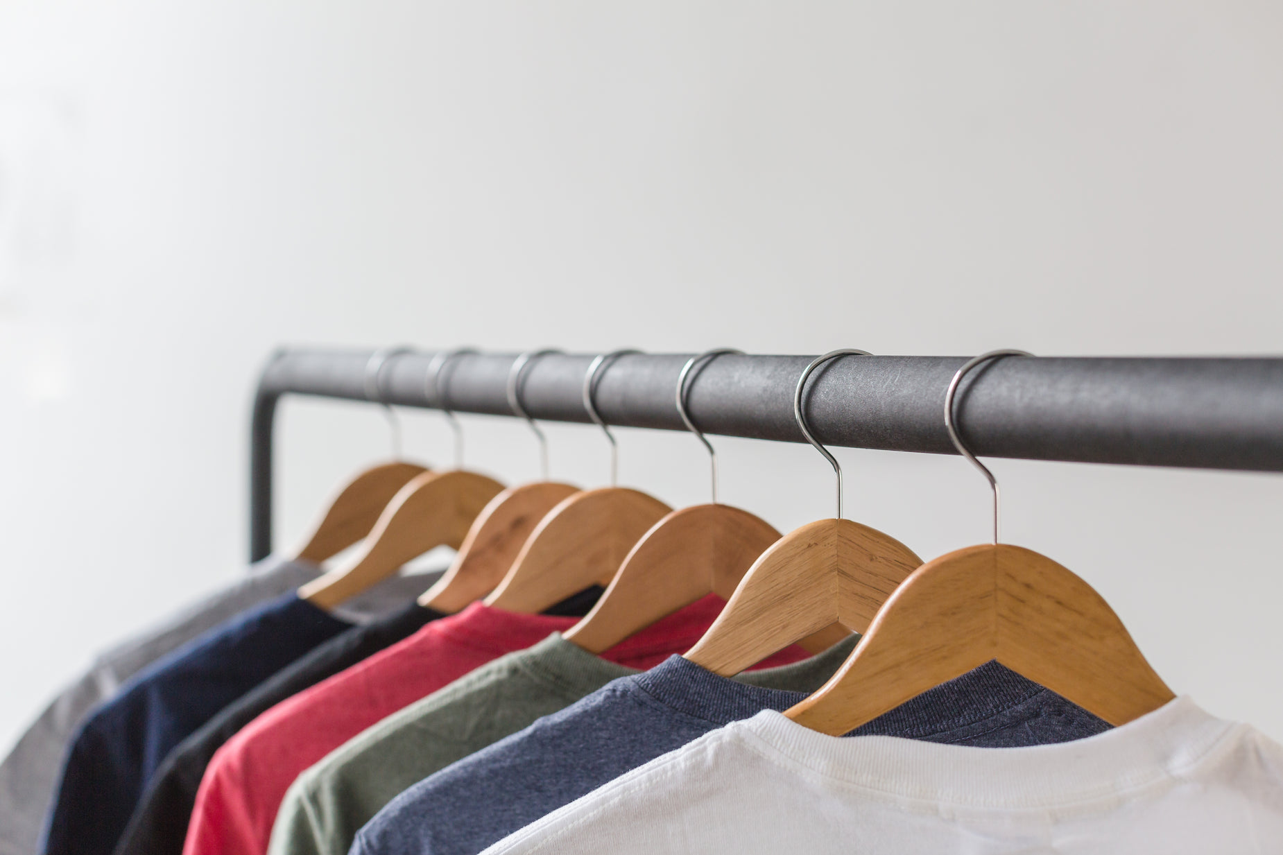 a clothes rack with colorful shirts hanging on it