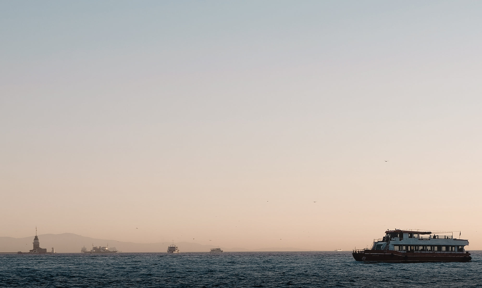 a boat traveling along the water towards light houses