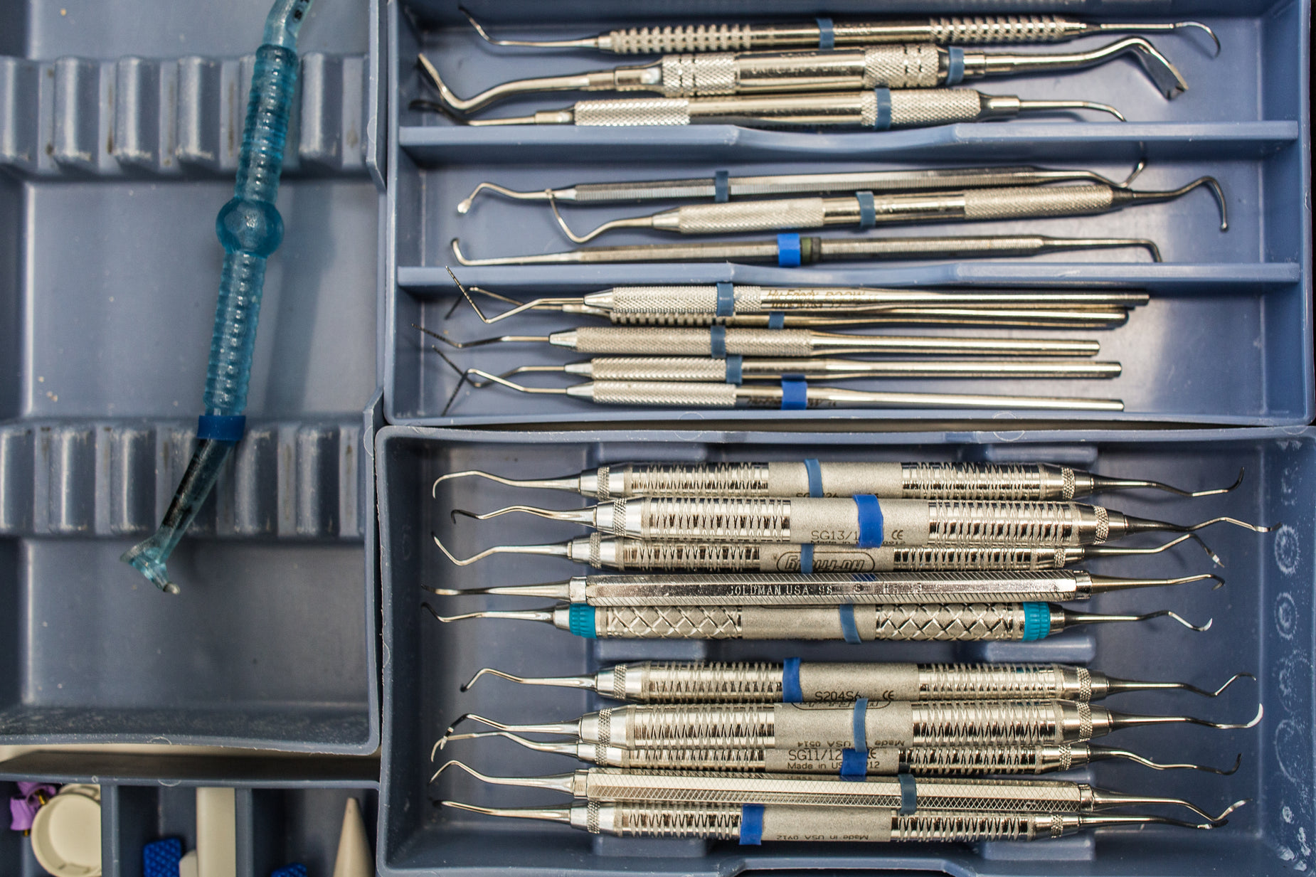 a medical tray full of silver and blue instruments