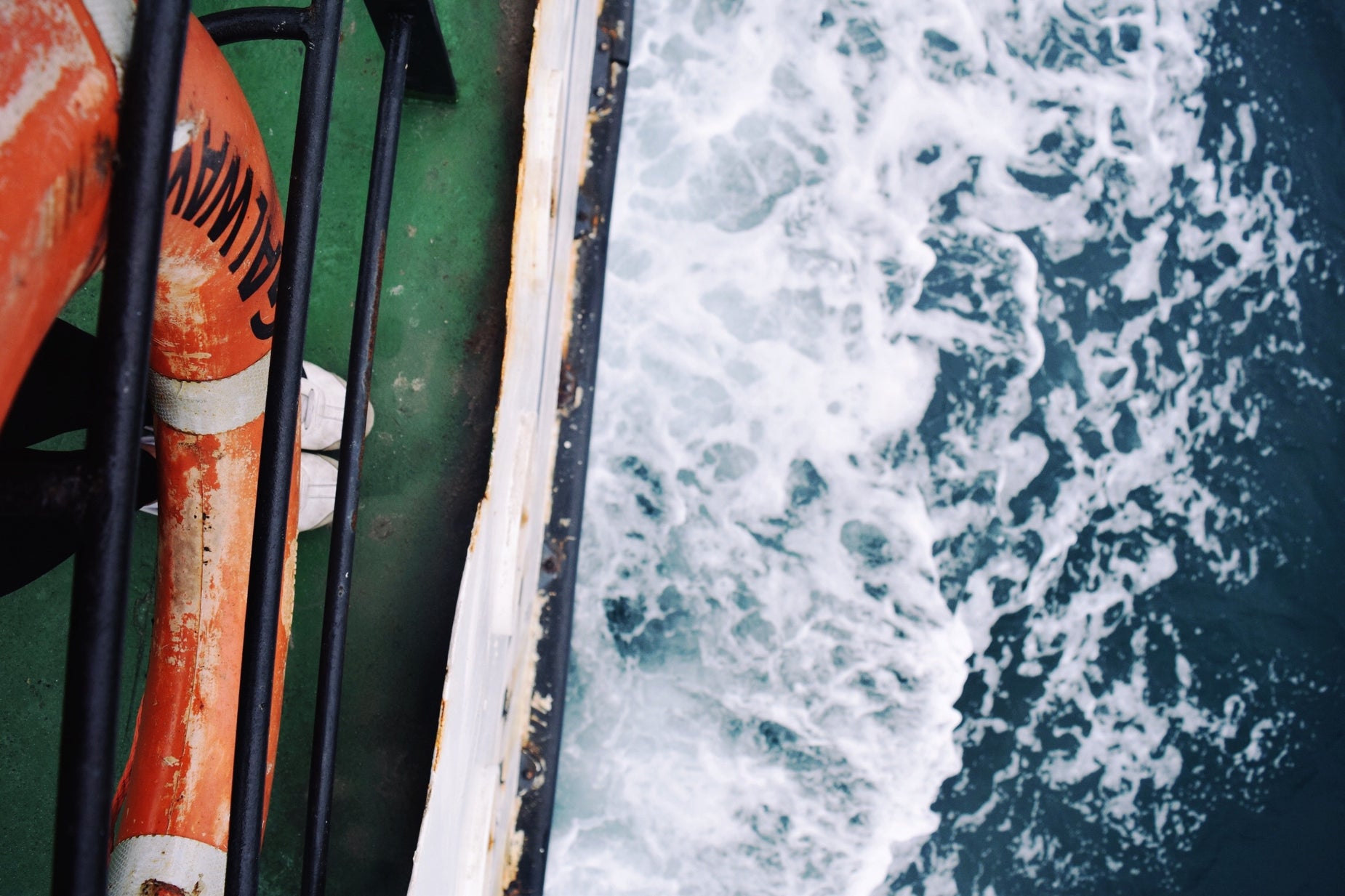 a life jacket and life buoy hanging near a body of water