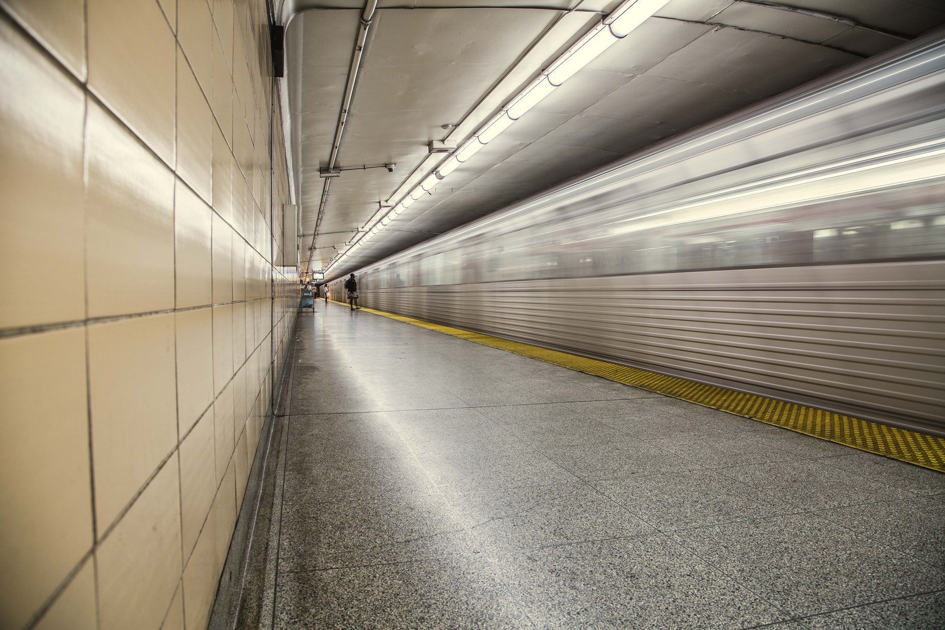 a subway train passes by an empty tunnel