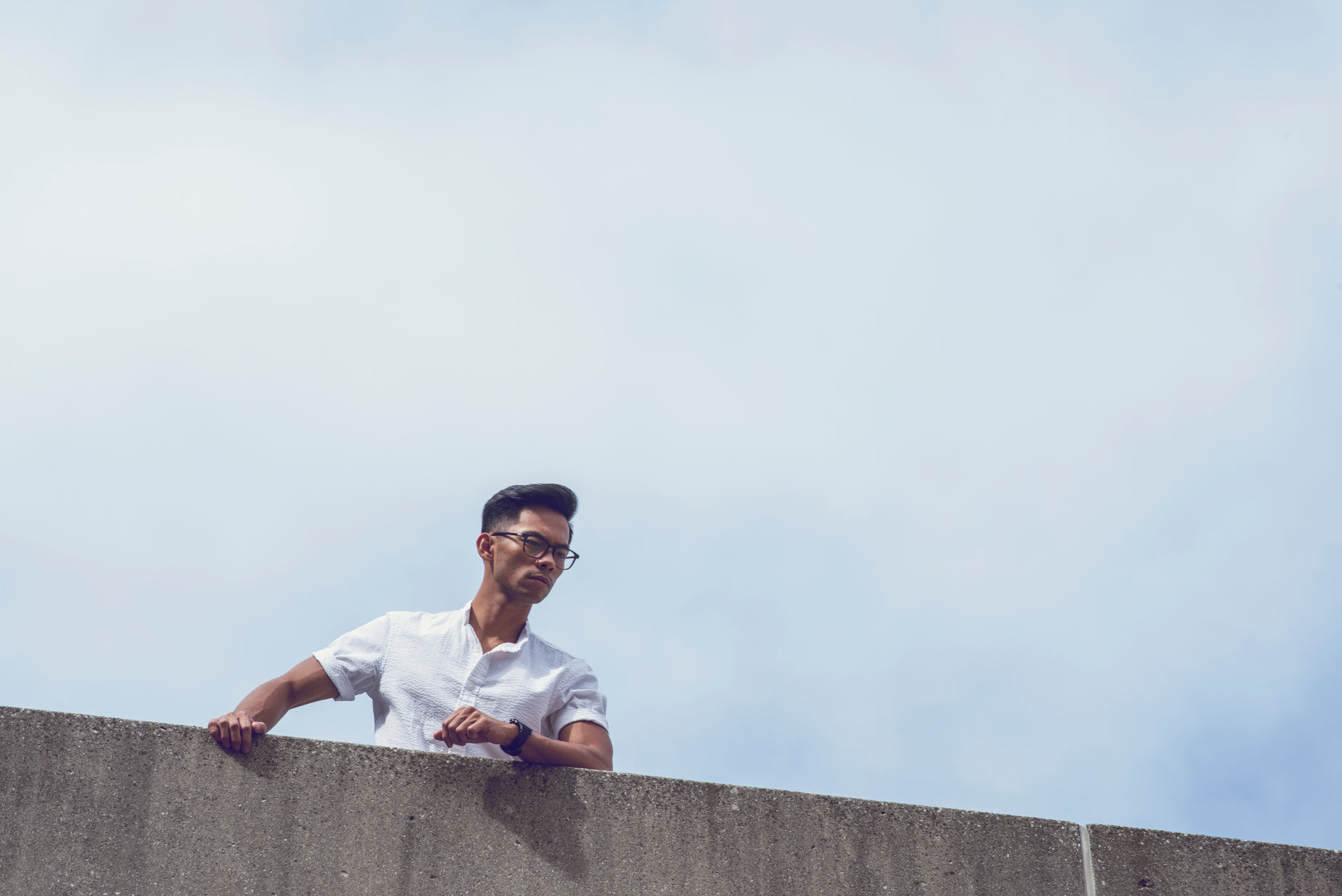 a man leans on the edge of an elevated building