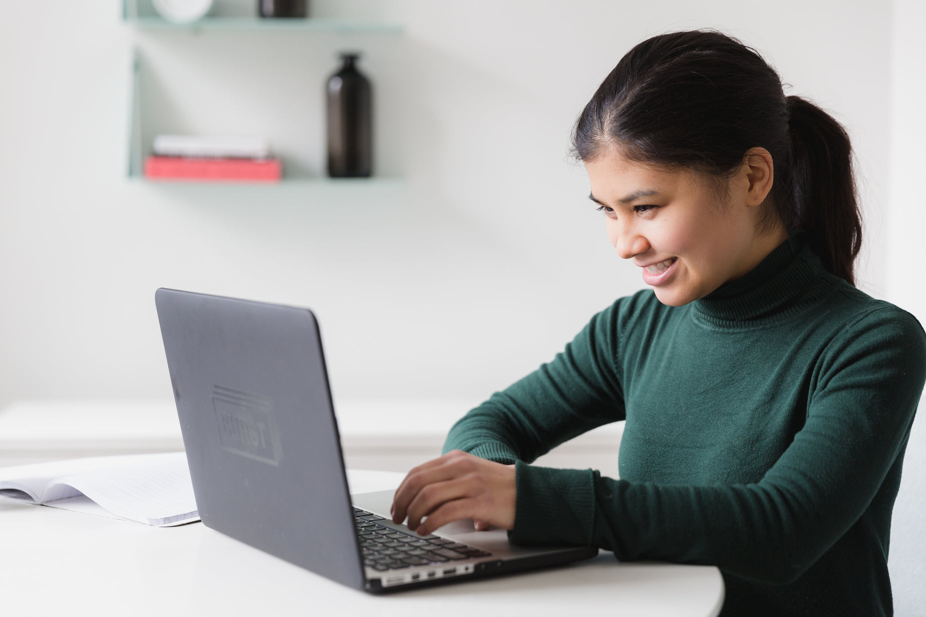 woman using a computer at a white table