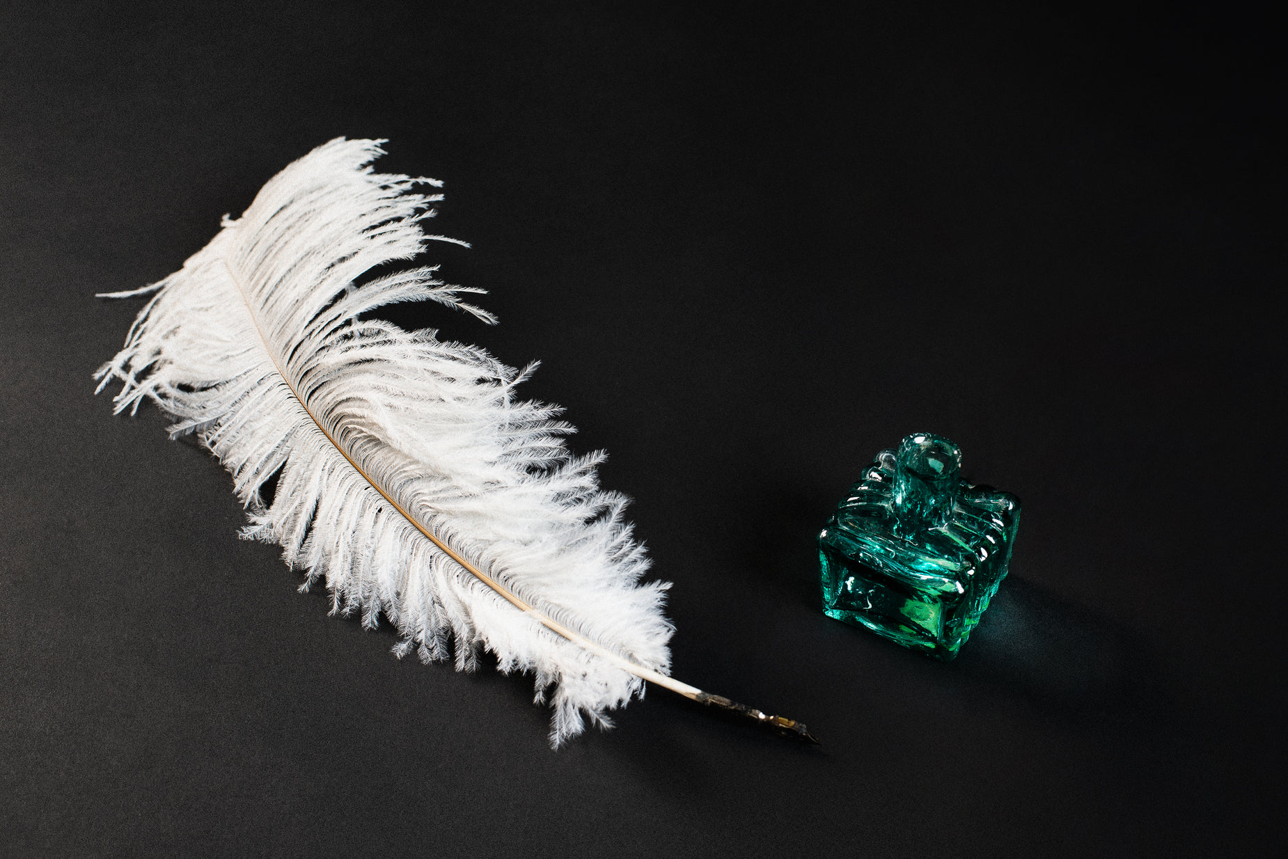 a feather sitting next to a green box