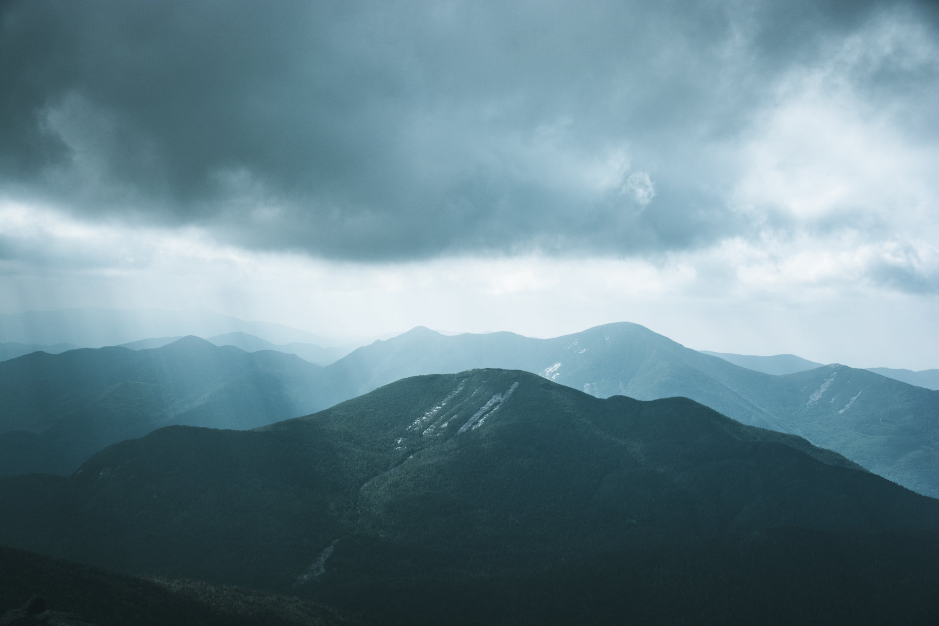 storm clouds moving over the mountains in the blue sky