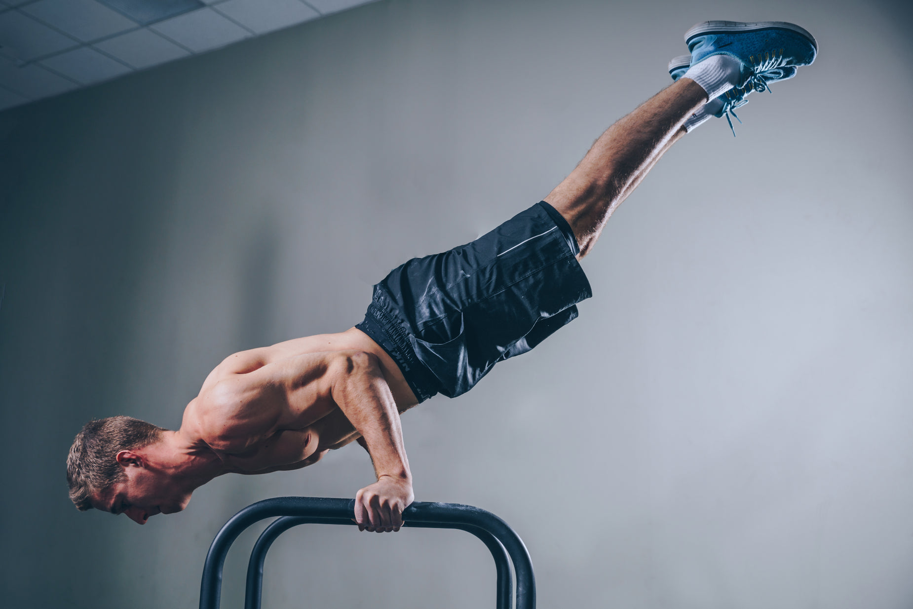 a man standing on one leg on the bar