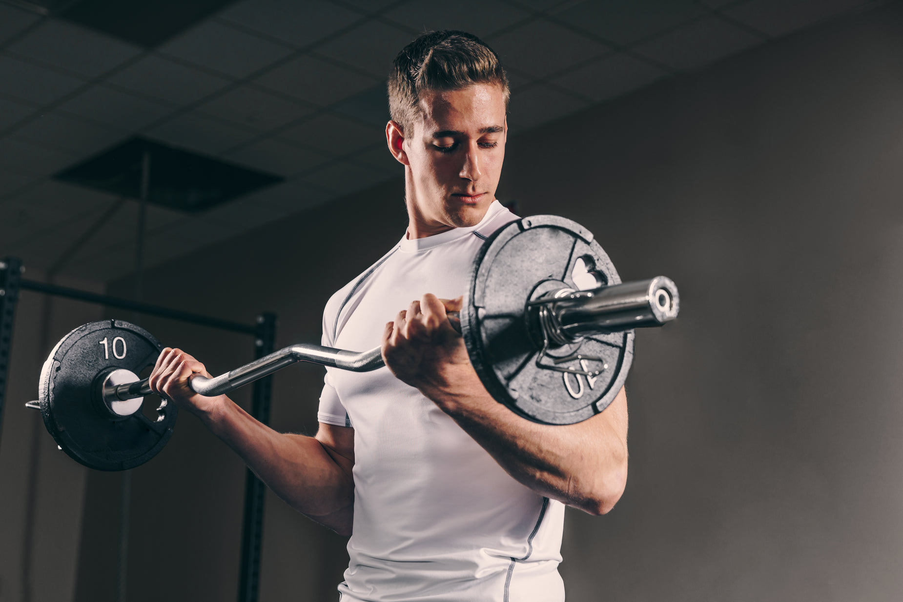 a man holding a barbell while standing in front of a weight scale