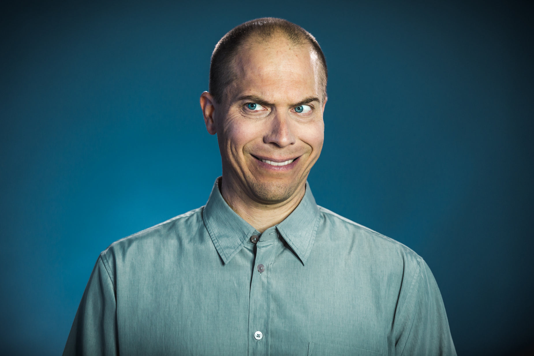 a man wearing a blue shirt has his head tilted in the middle