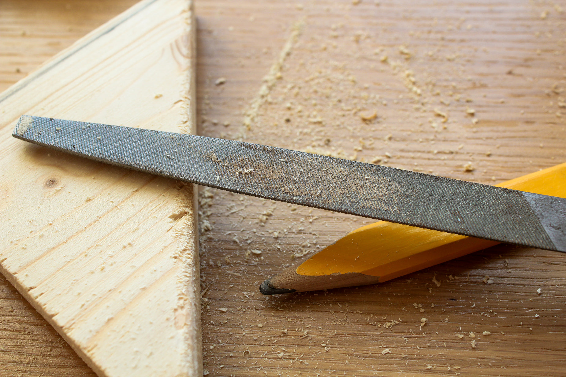 a pair of scissors with their handles resting next to some wood