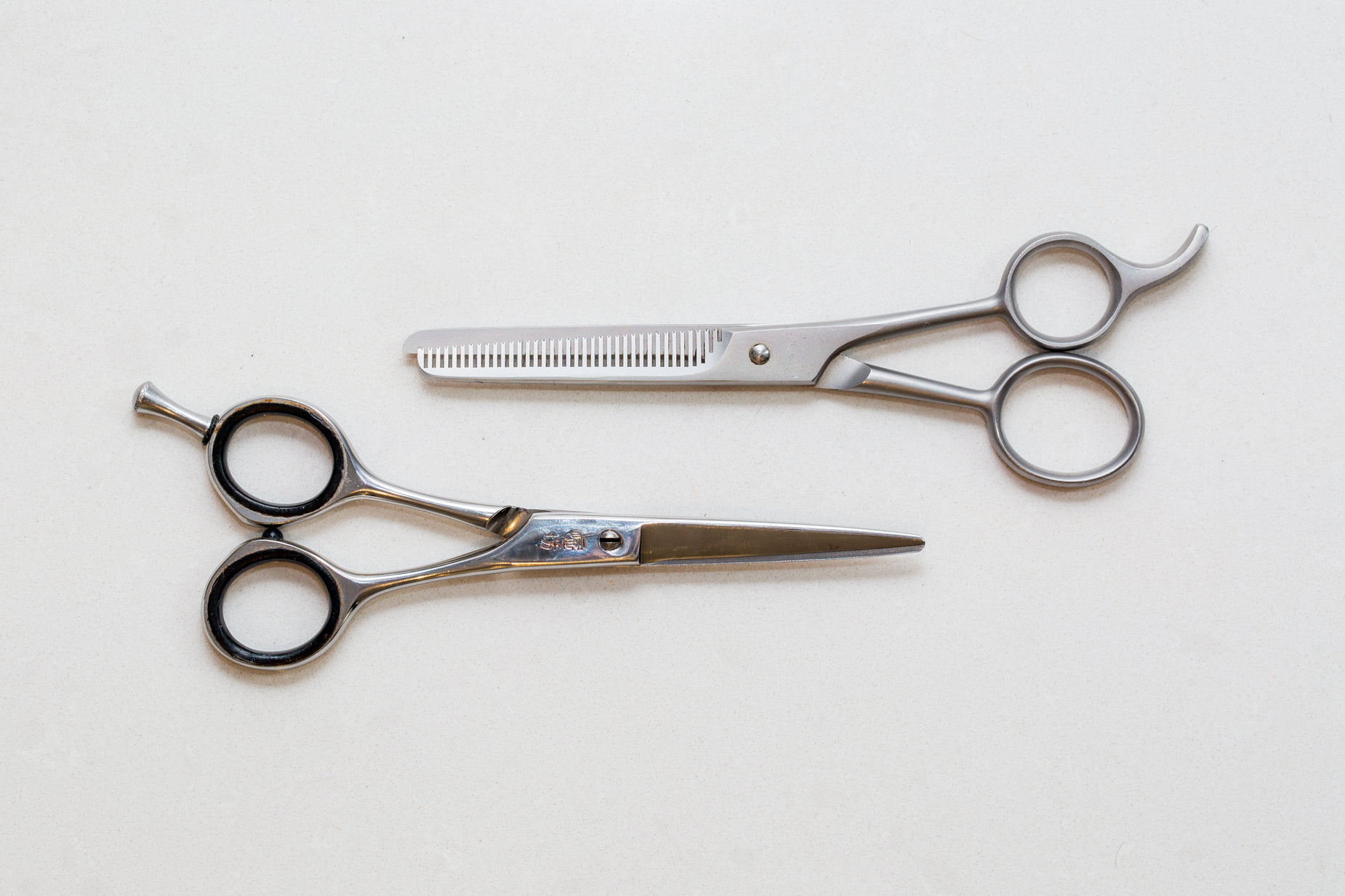 pair of scissors and comb lying on white background