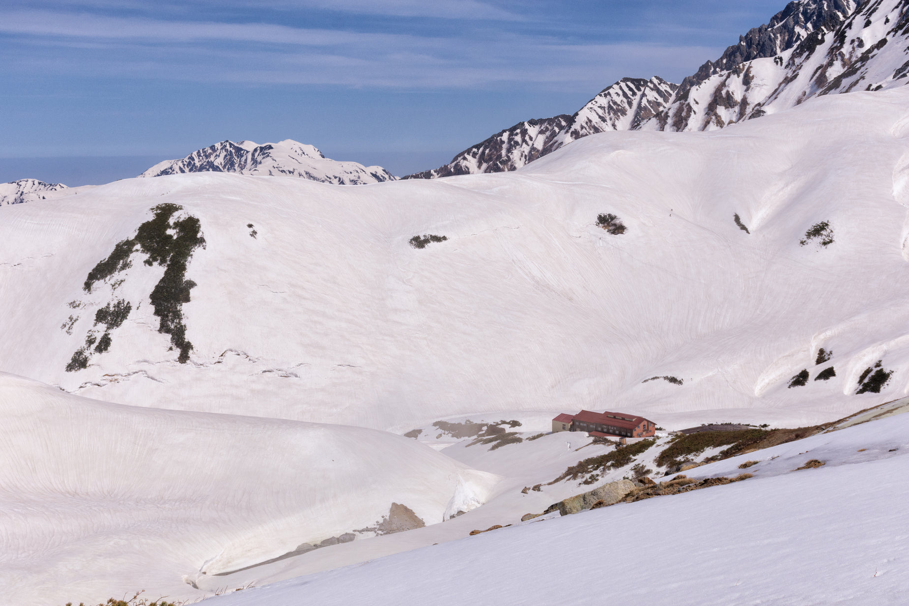 snow - covered mountains and a lone skier on top