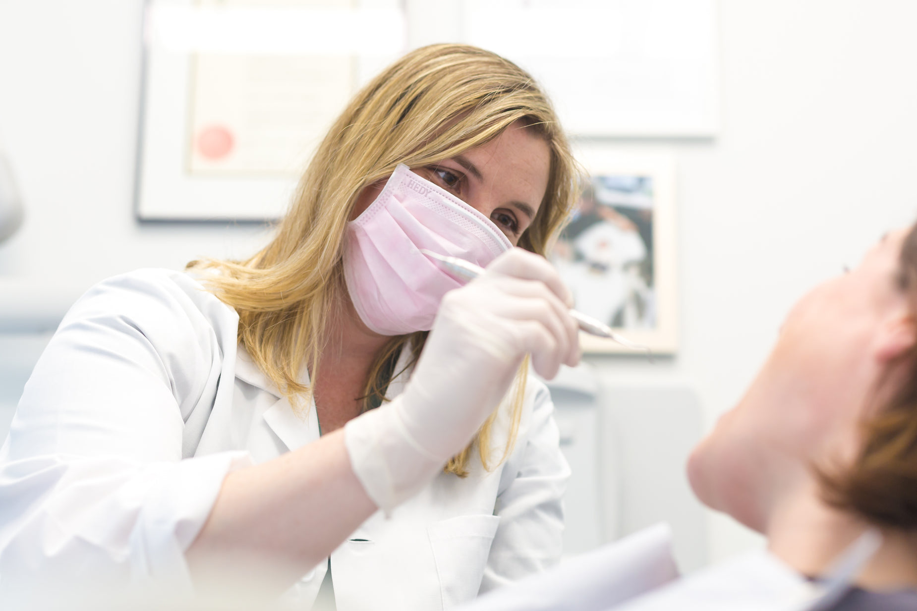 a person wearing a pink mask putting on gloves