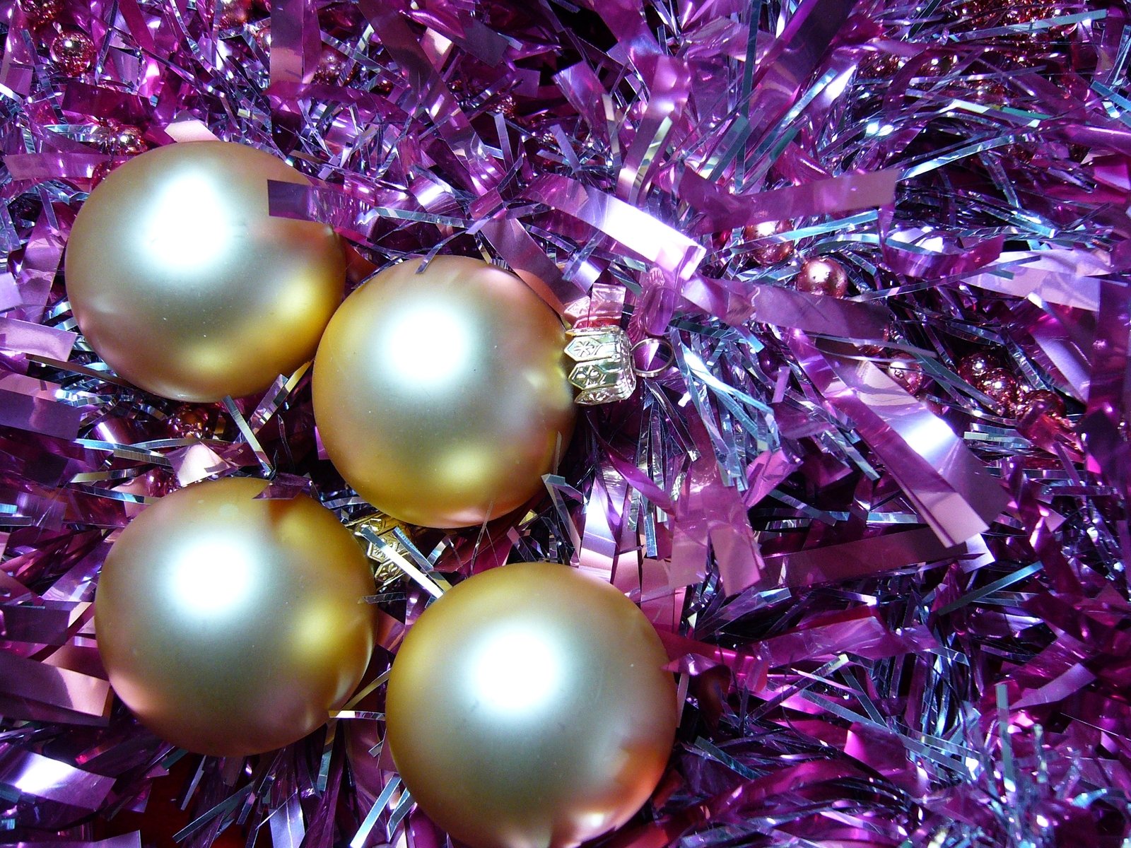 a close up s of christmas ornaments with purple tinsel