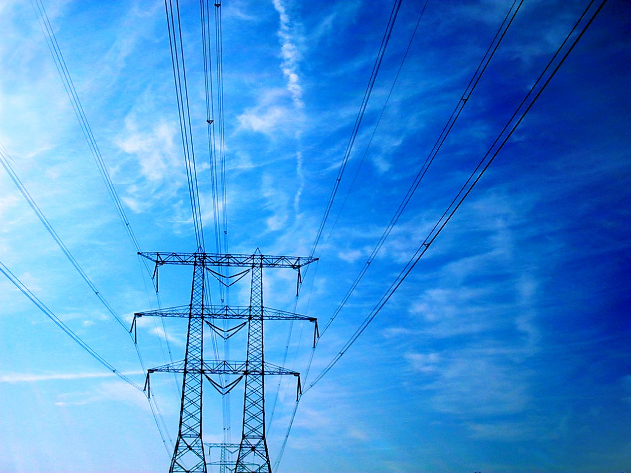 electric pylons are against the blue sky