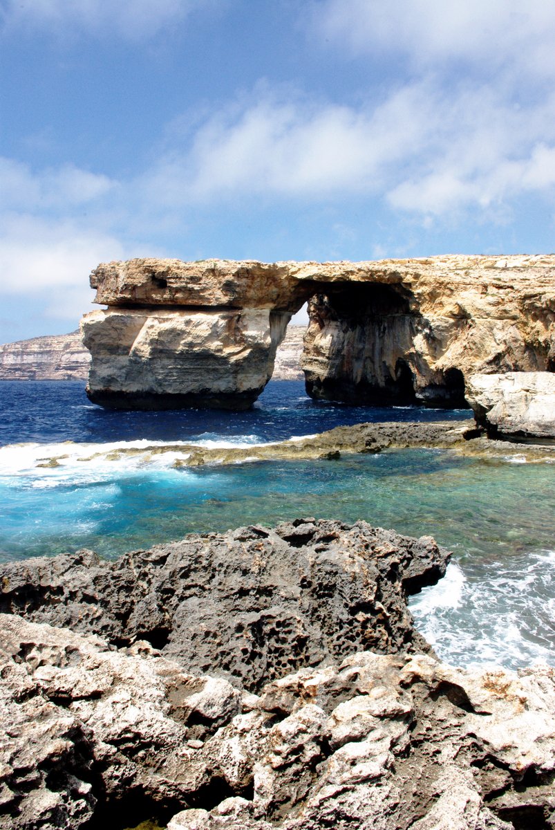 rocky shoreline near an open, majestic cliff face