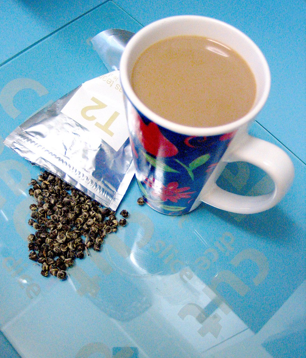 a coffee cup, a packet of loose tea and some seeds
