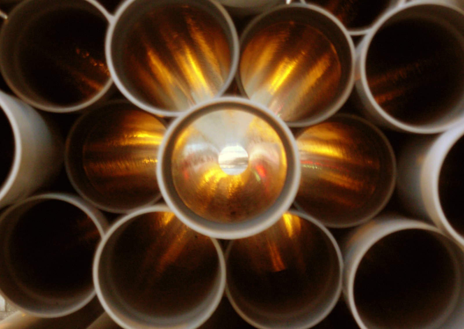 a bunch of metal pipes with reflections on them