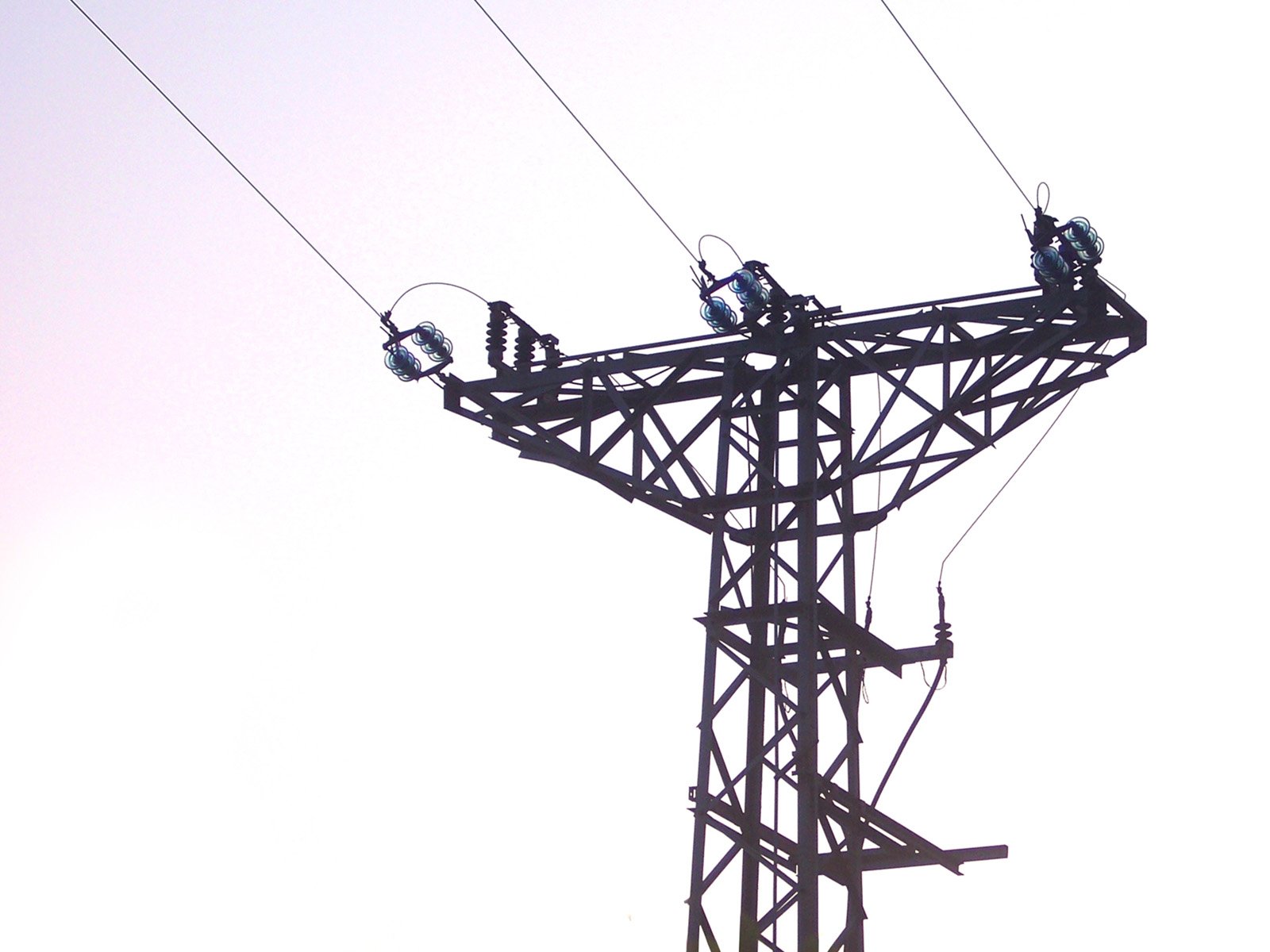 some power lines against a pale blue sky