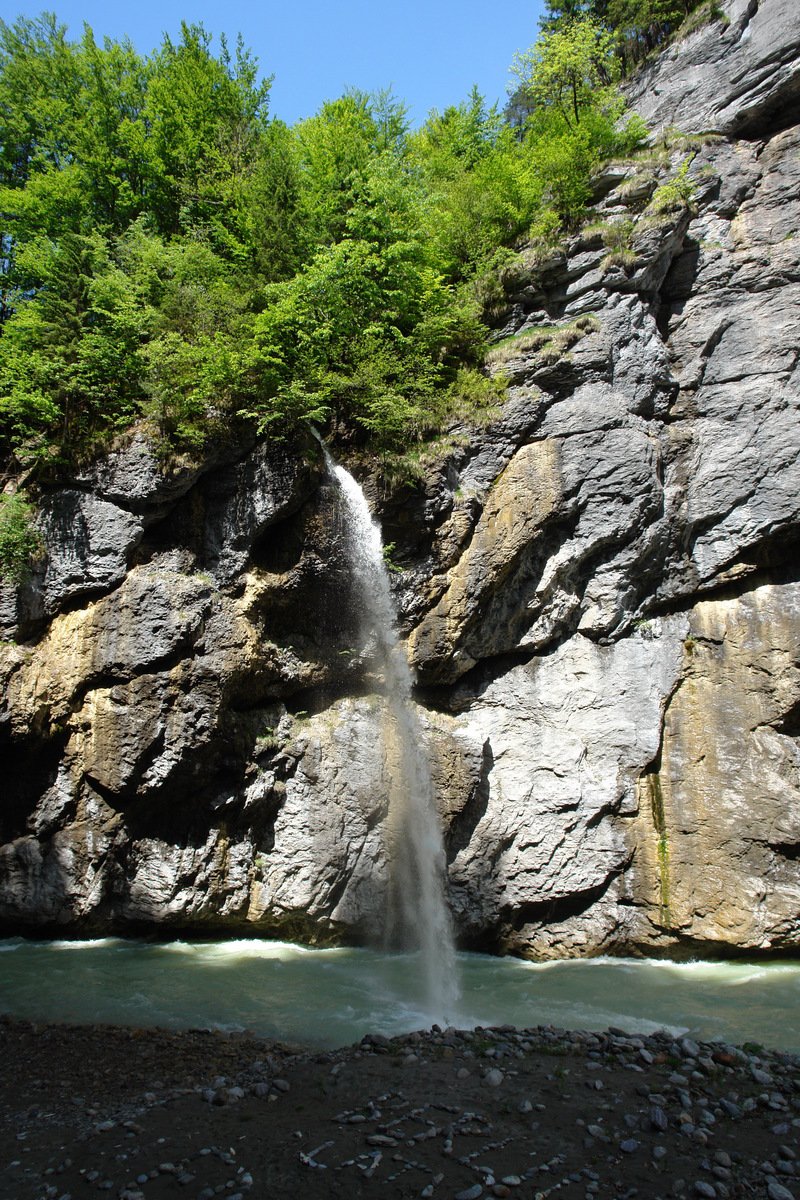 a waterfall and river with many rocks below