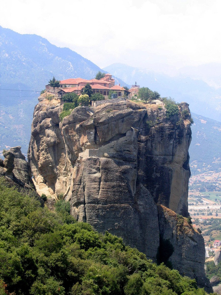 a tall rock with a small house built into it