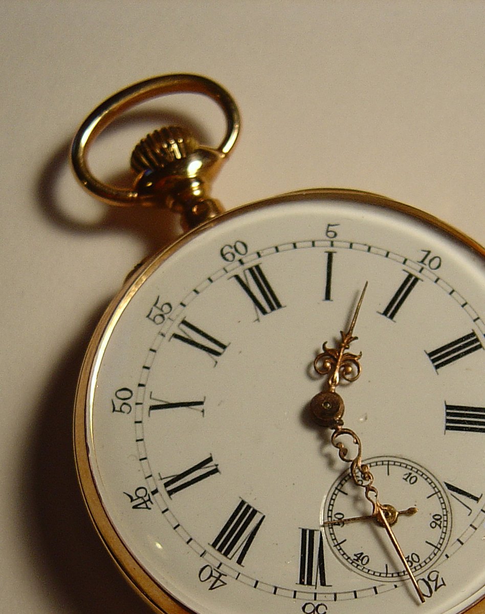 an antique gold pocket watch with roman numerals and date