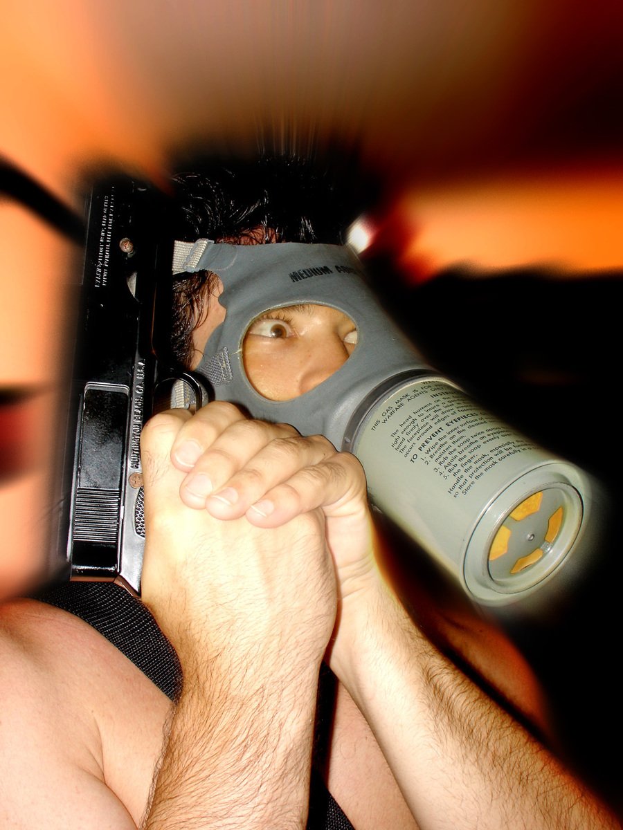 a person holding a gun with a bottle hanging off of it