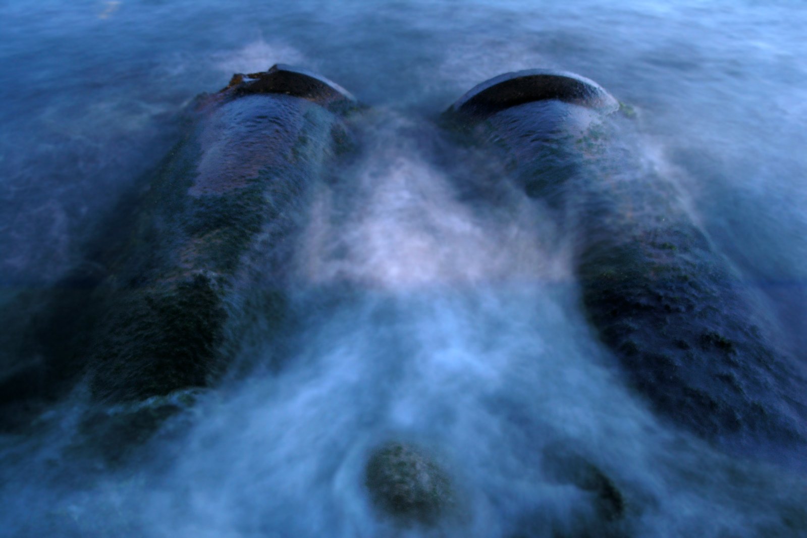 a close up view of two long pieces of metal floating on water