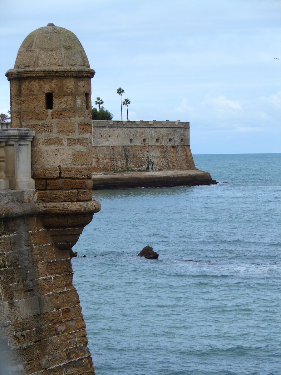 two large, old buildings next to the ocean