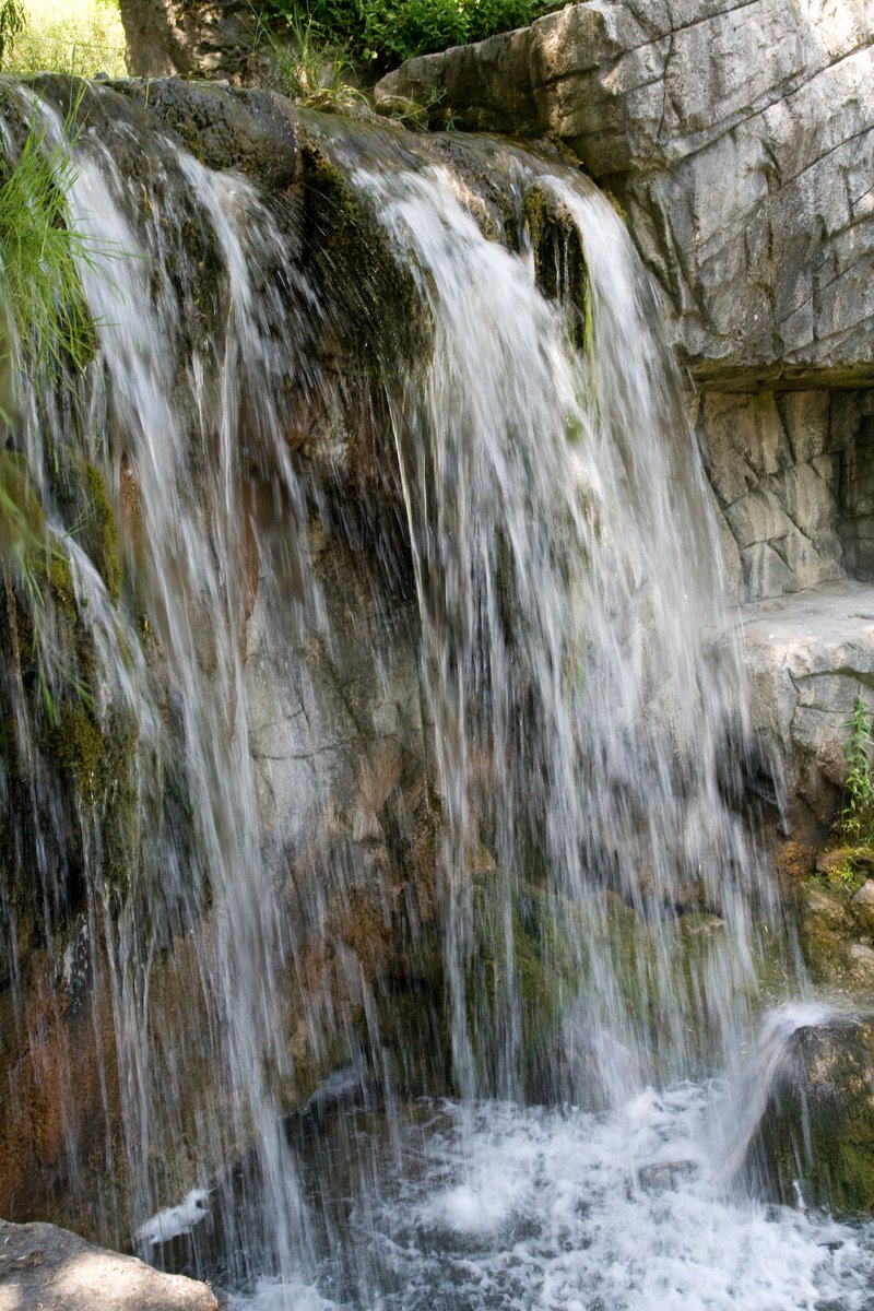 waterfall in open water with rocks surrounding it
