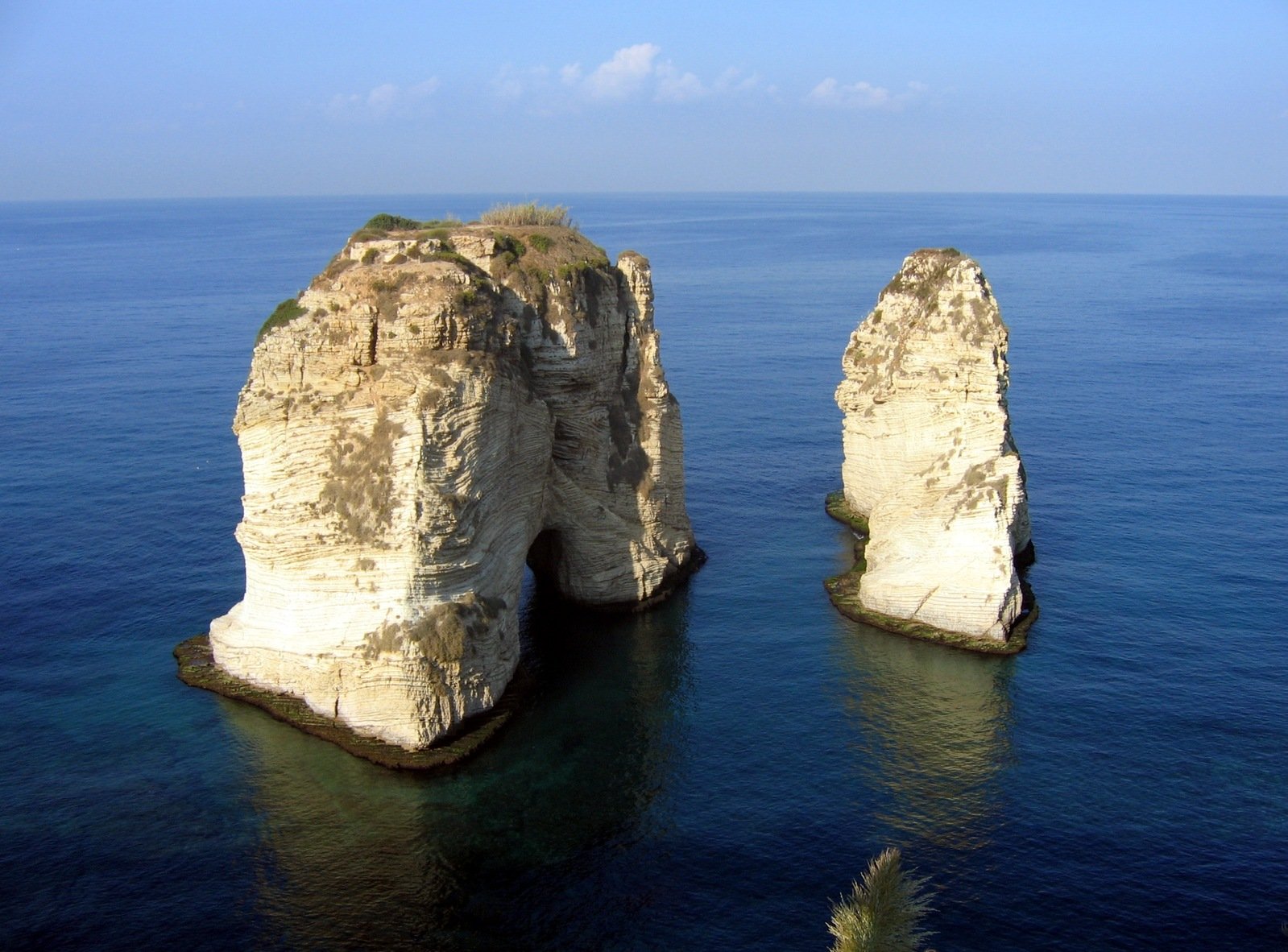 a rocky cliff on the side of a large body of water