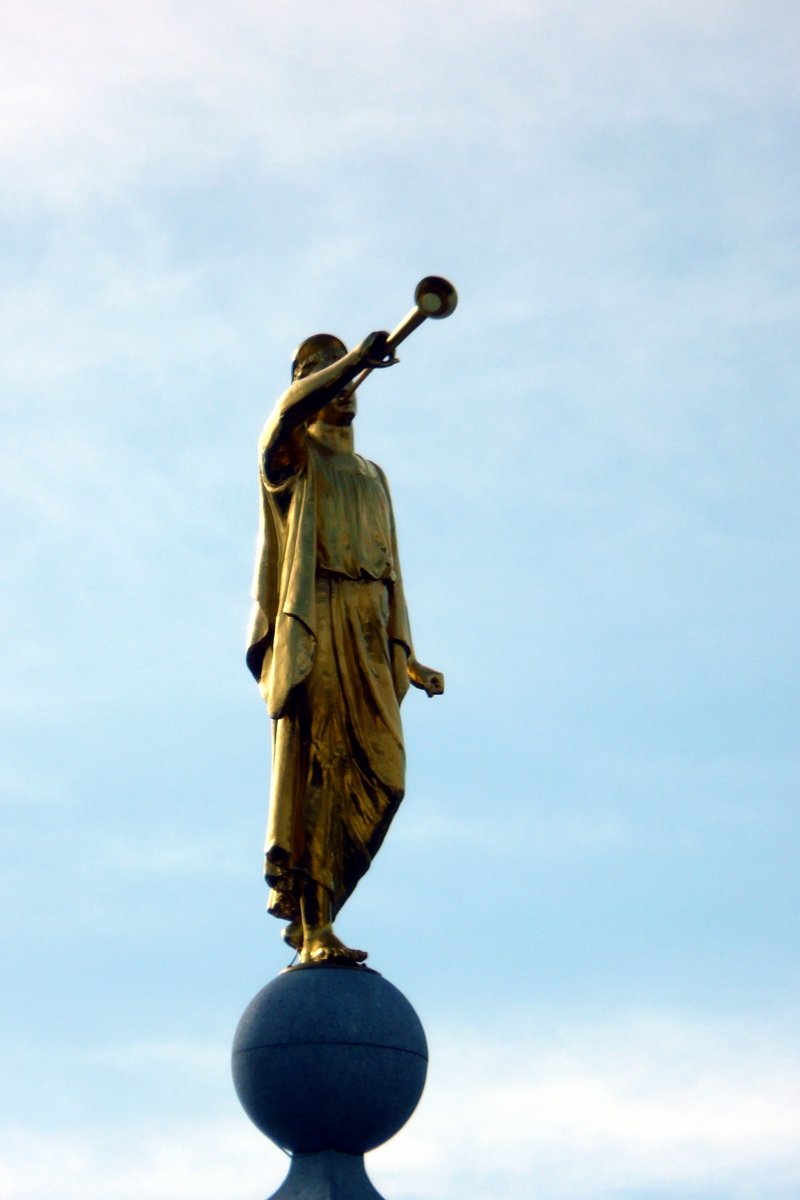the gold statue is atop of a building