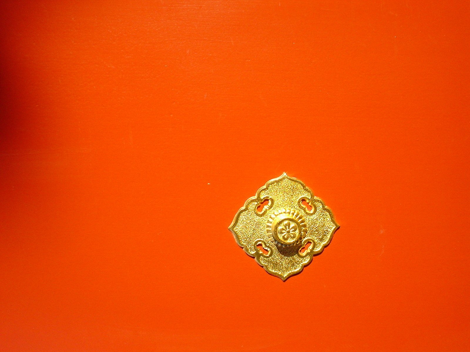 an ornate golden object against a red background