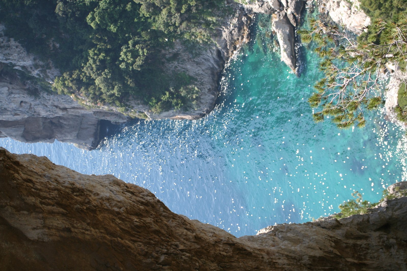 blue water between large rocks and a cliff