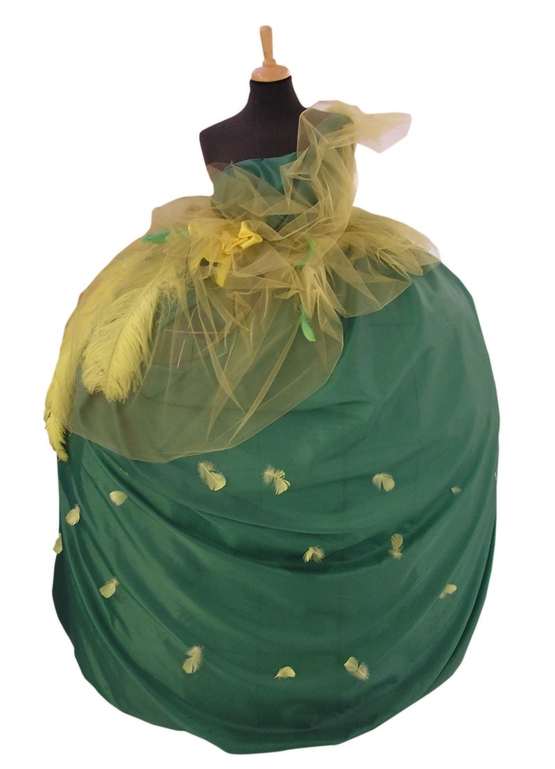 a green dress and a black hat sitting on top of a mannequin