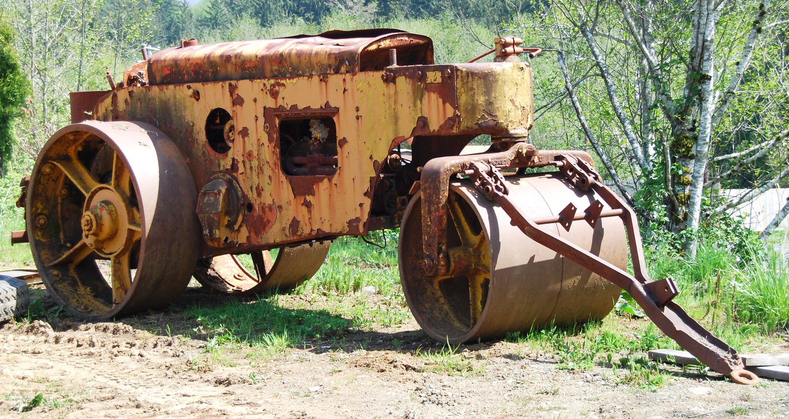 a old tractor parked on top of a dirt field