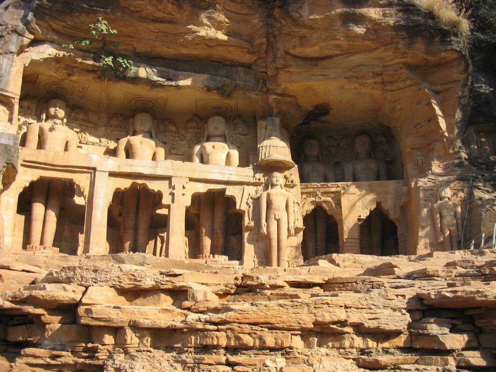 a couple of statues sitting in the middle of some rock