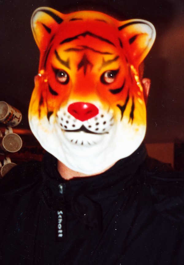 a man wearing a tiger mask with coins behind his head