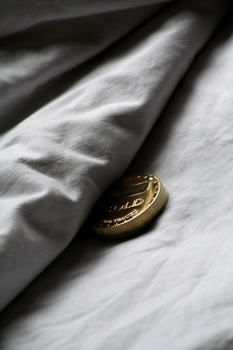 the white bedding with a on is under a white sheet