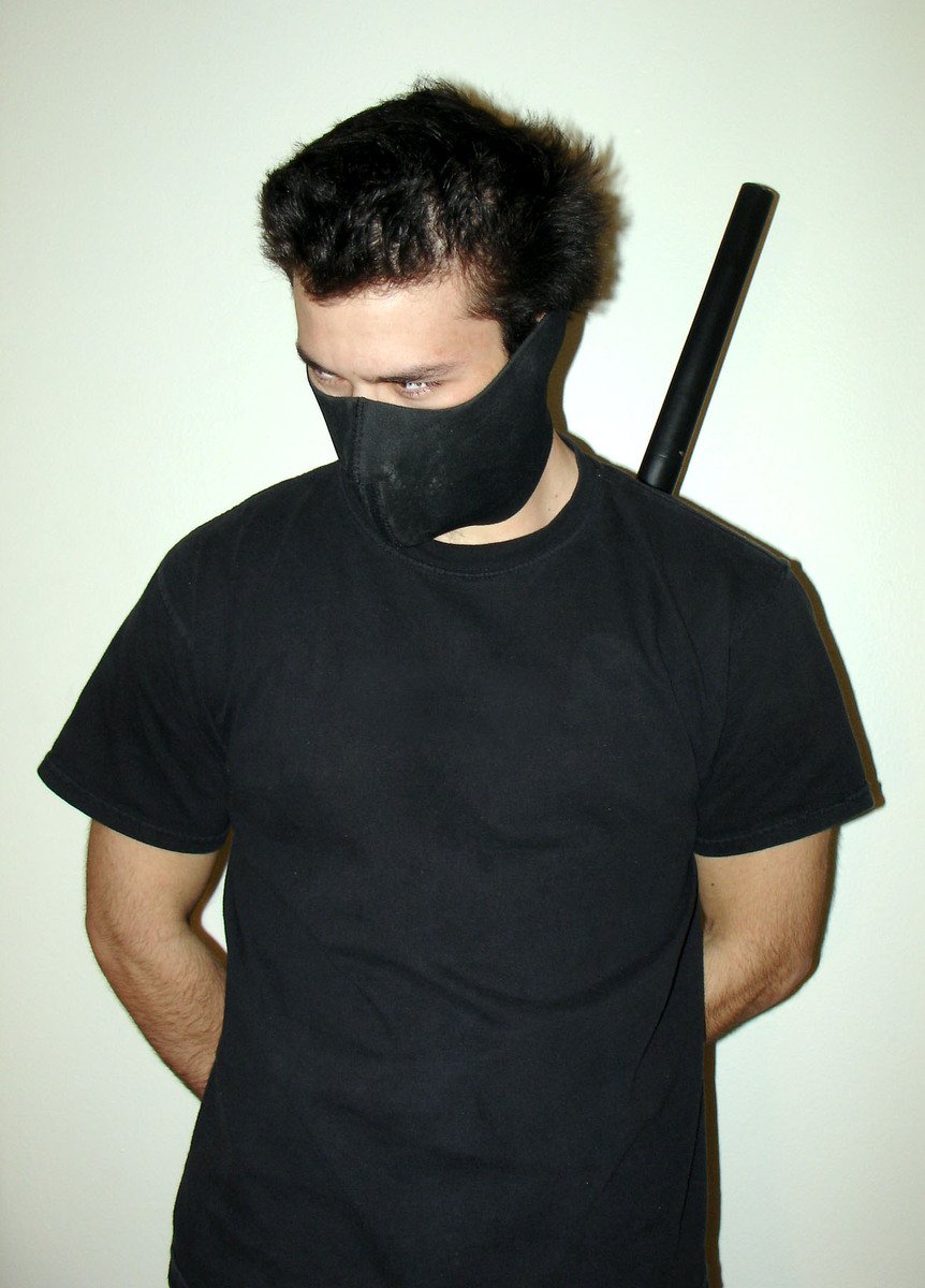 a man wearing a neck gaiter holding a baseball bat