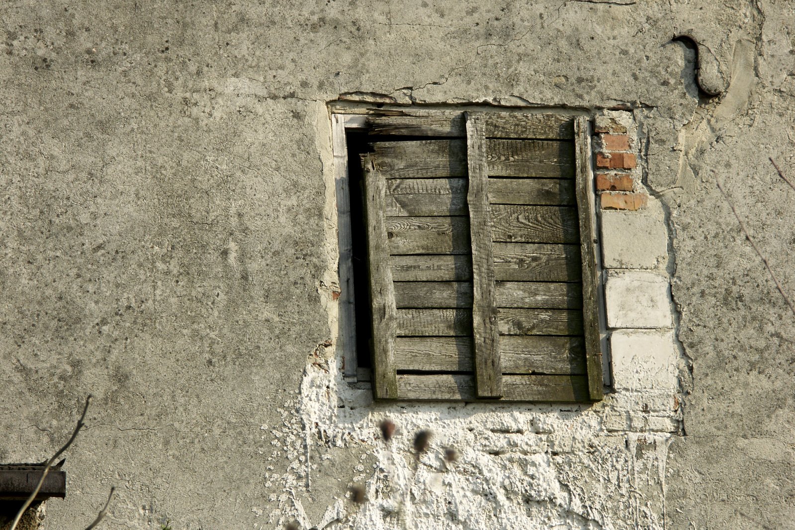 a window and wooden sill on a cement wall