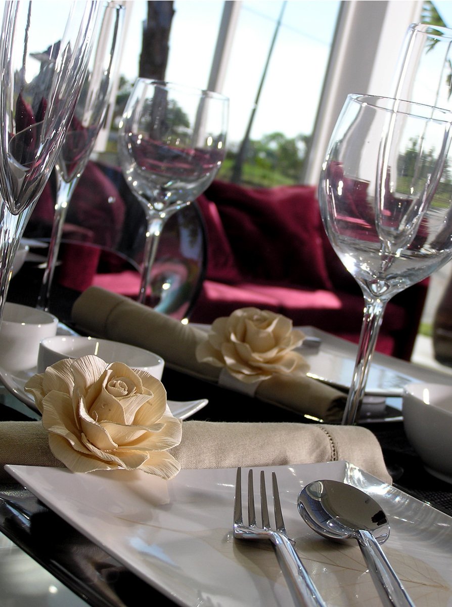 a bunch of white plates and napkins in a restaurant